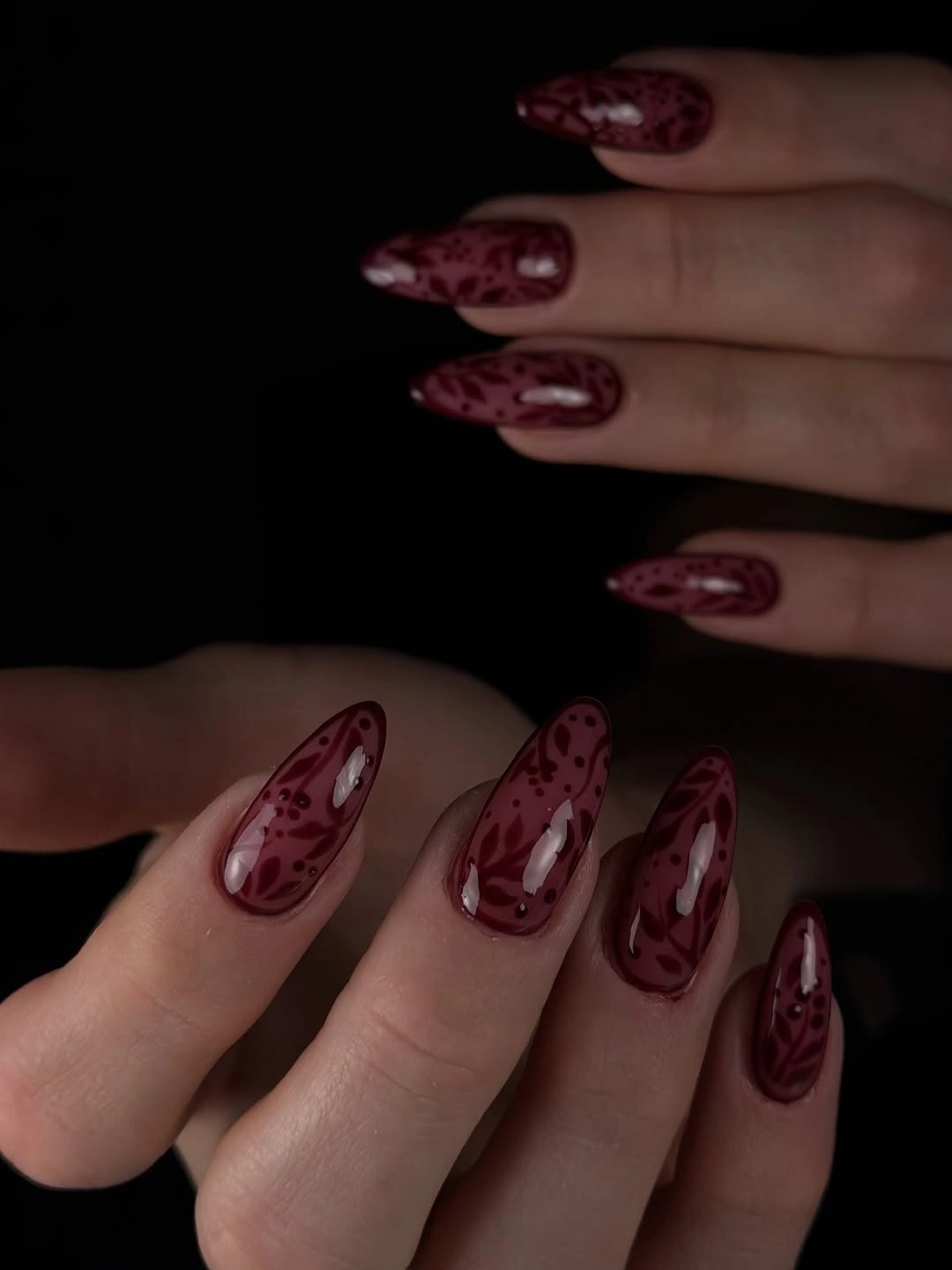 long almond burgundy nails with dark abstract marbled accents