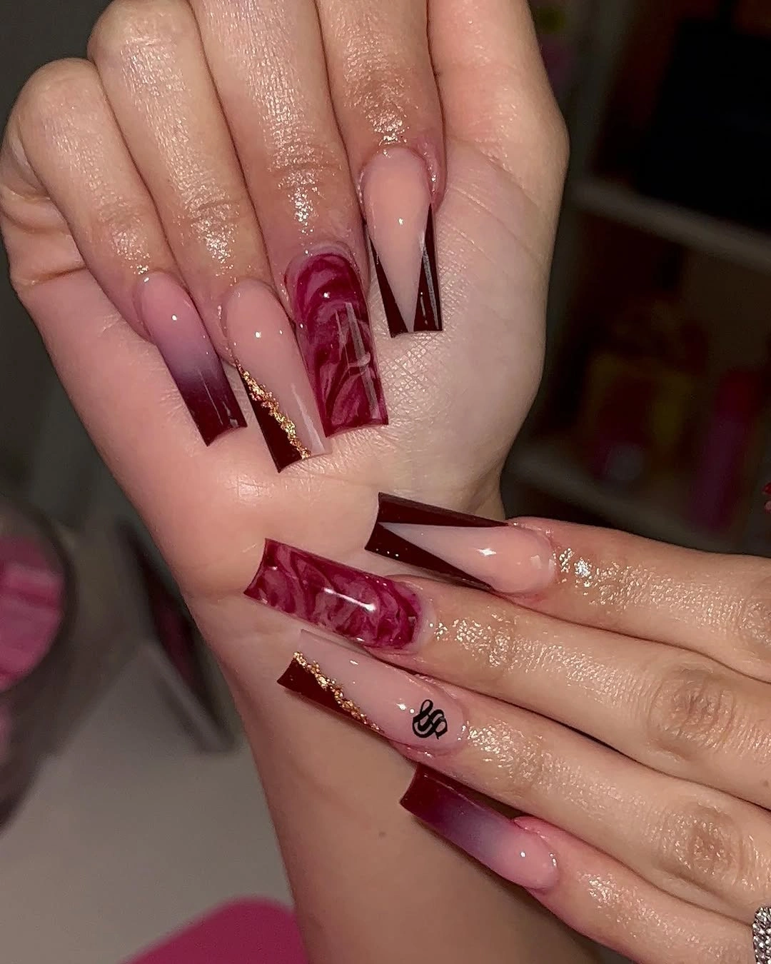 long pointed nails with burgundy blocks and fine gold separators