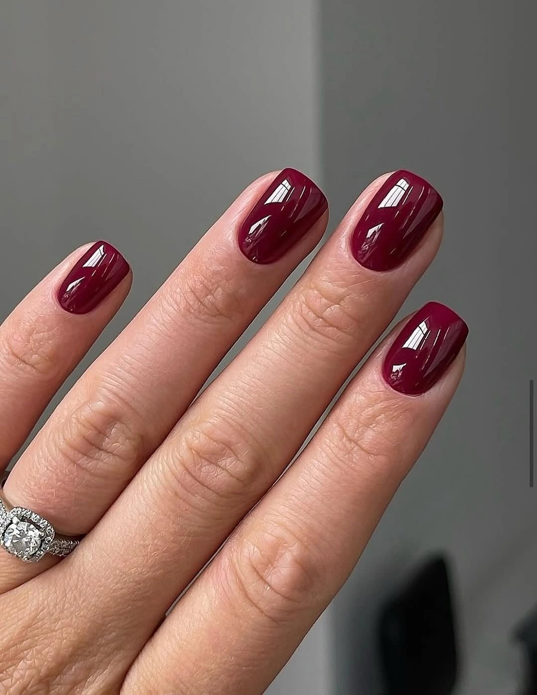 short square nails in a uniform glossy burgundy color