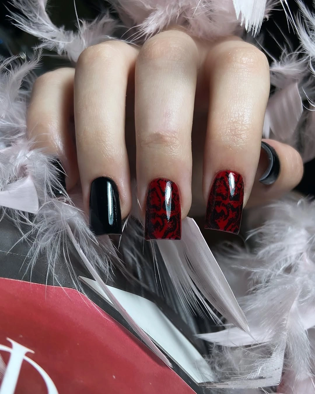 black square nails with red patterned accents