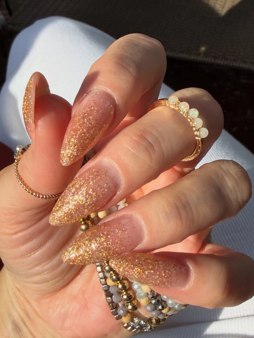 Long almond nails with even warm champagne gold glitter