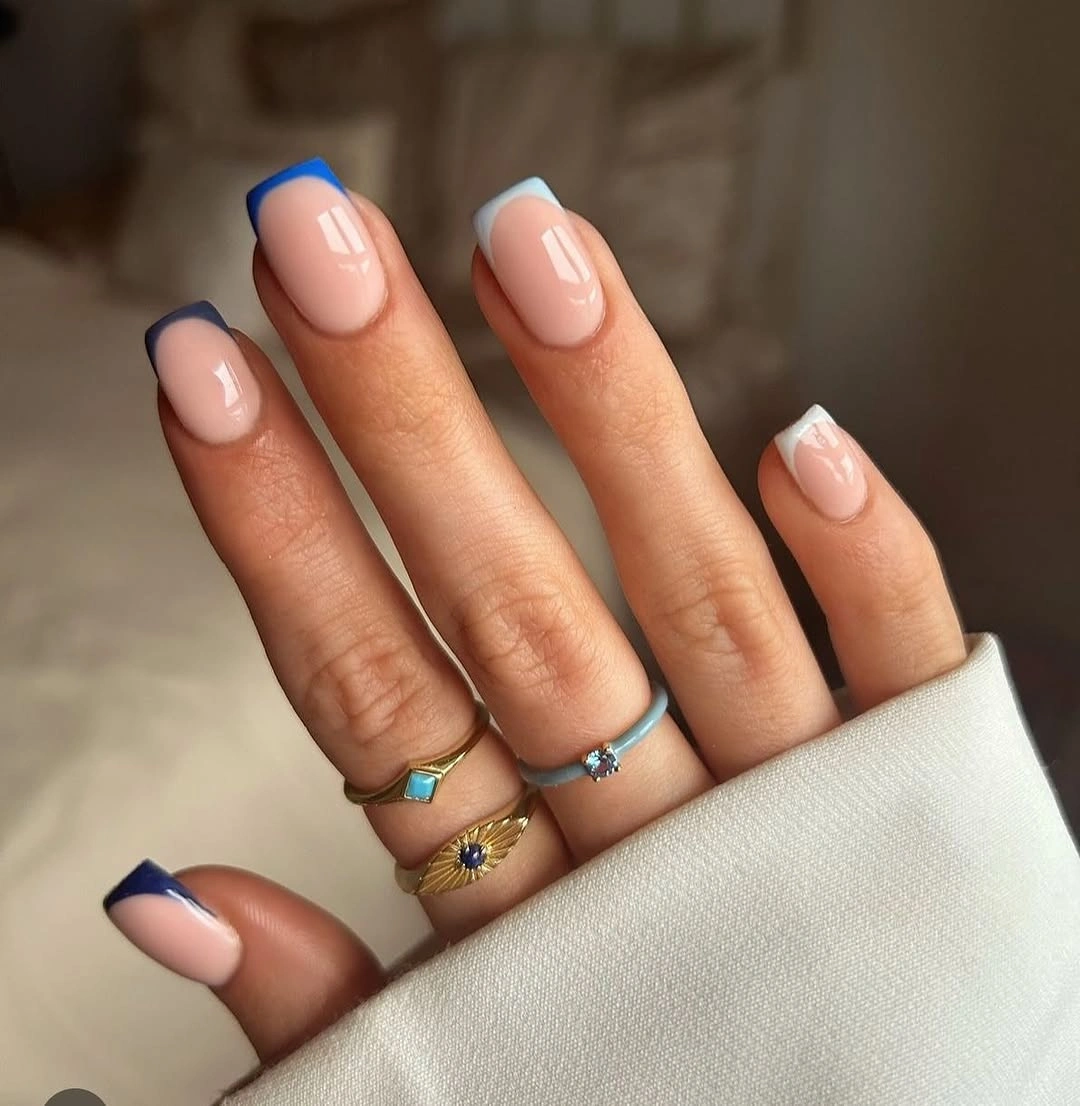 Short nude squoval nails with deep navy curved French edges