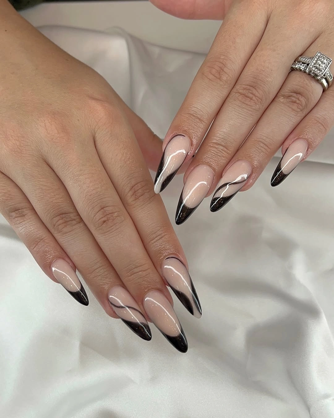 Long nude almond nails with layered black and white French curves
