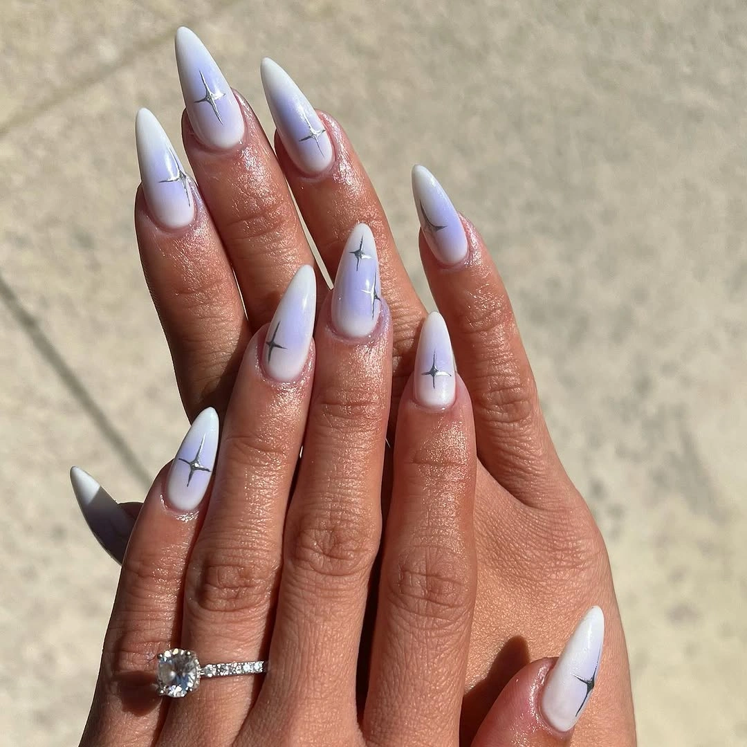 Very long icy blue stiletto nails with flowing white abstract shapes