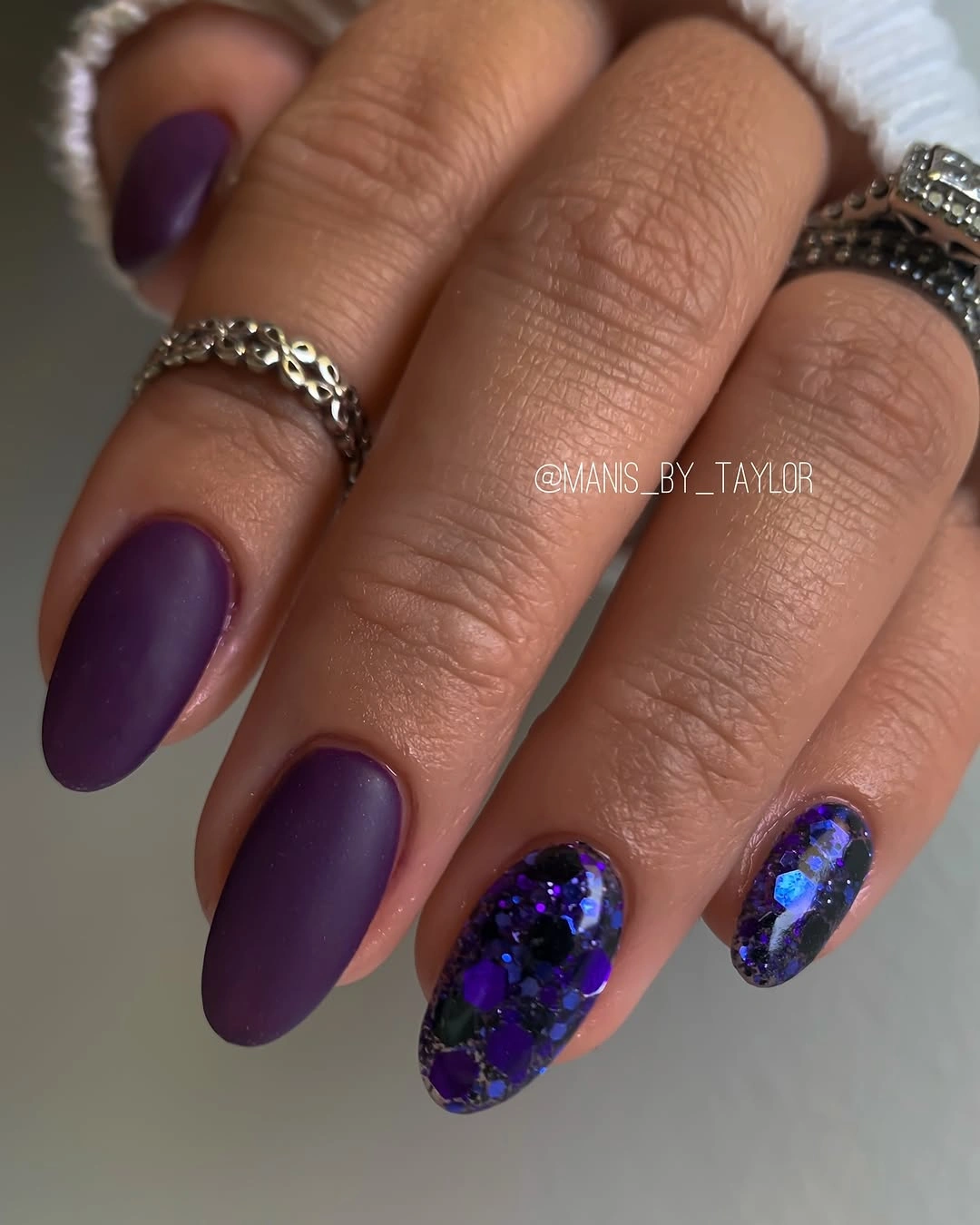 Matte eggplant almond nails with blue violet glitter accent nails