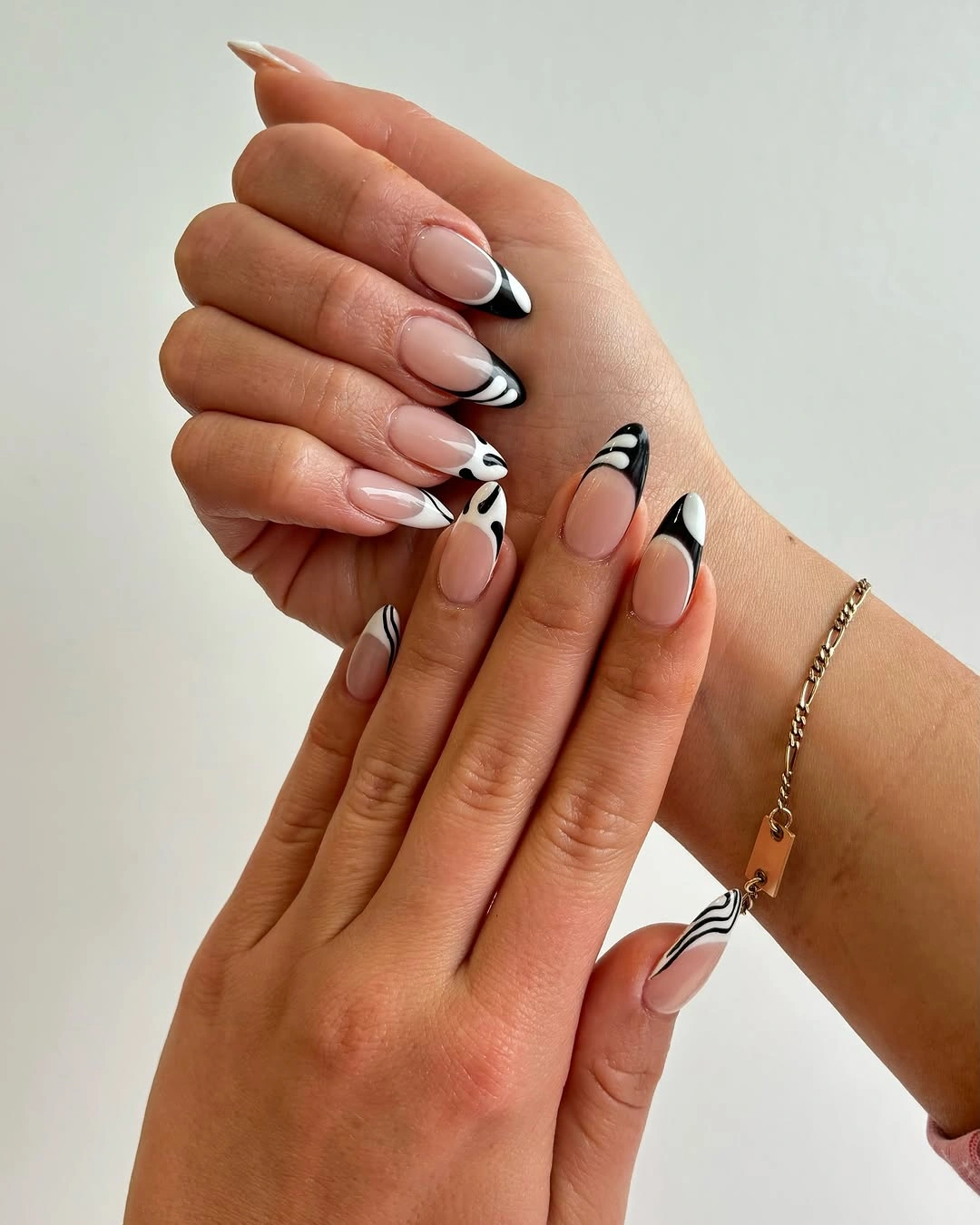 Pale nude oval nails with black and white abstract tip motifs