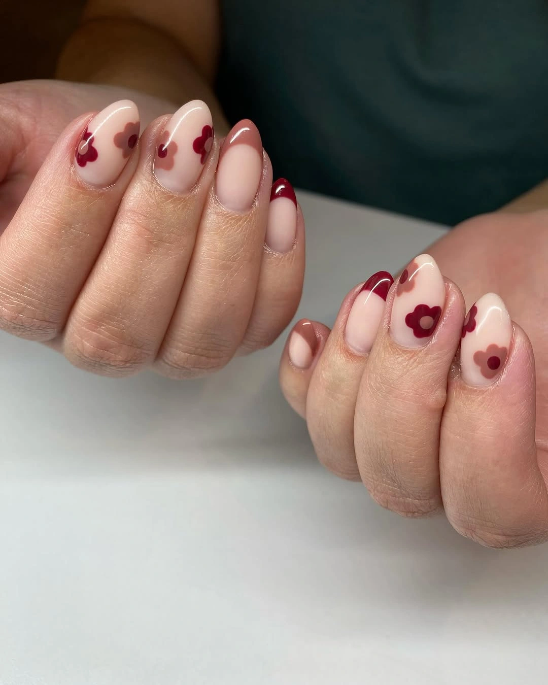 Short rounded pink nails with tiny berry red floral accents