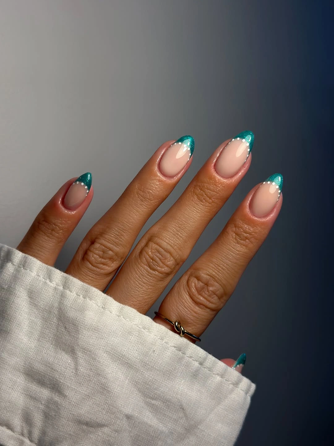 Medium almond nude nails with saturated teal French tips