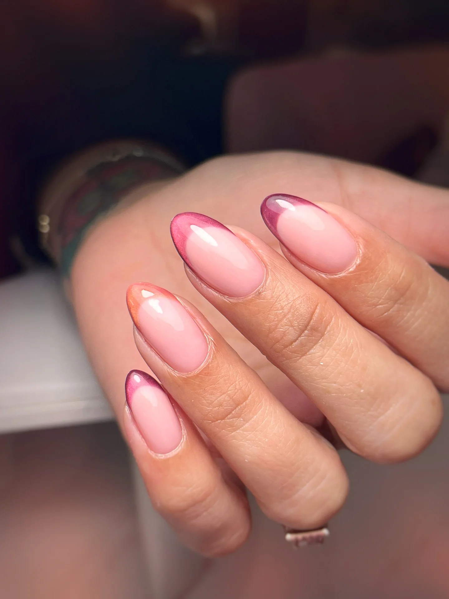 Short almond blush nails with a fine metallic French curve