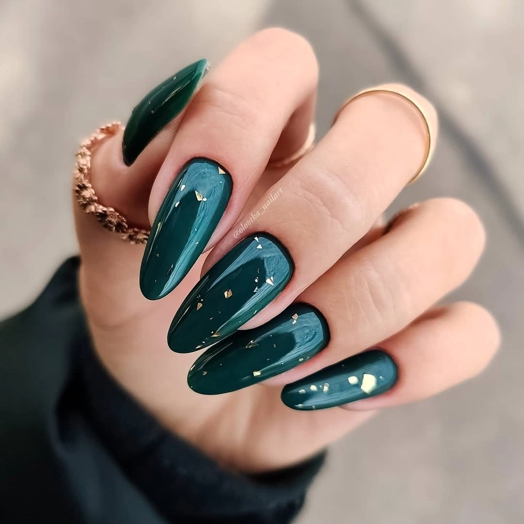 Deep teal almond nails with small pale reflective marks