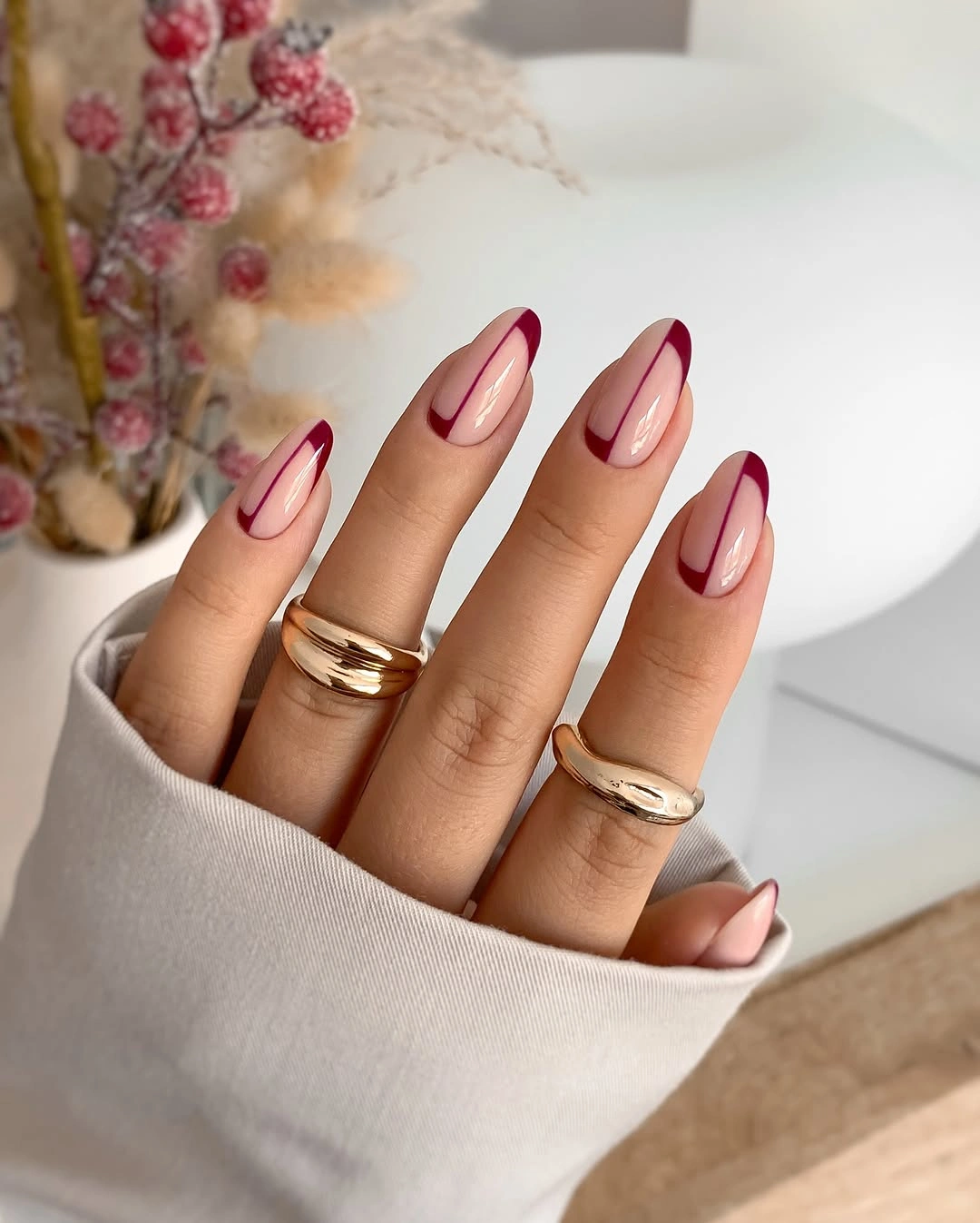 Sheer pink almond nails with burgundy French edges