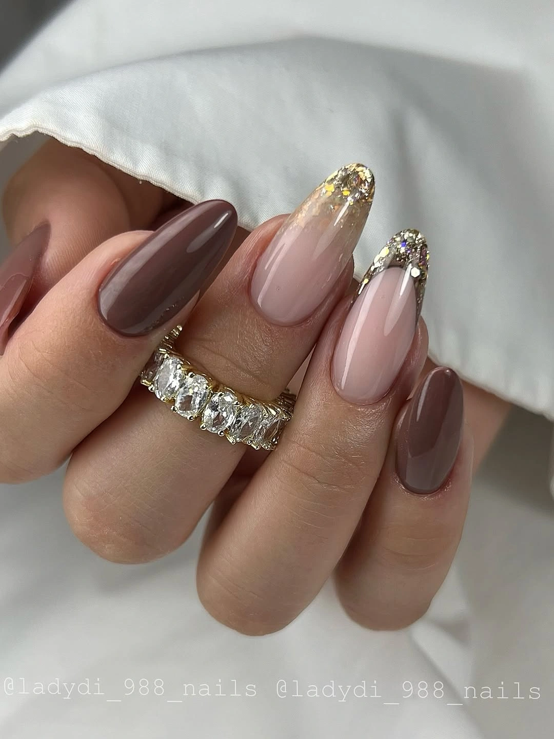 Brown blush almond nails with gold edges and floral lines