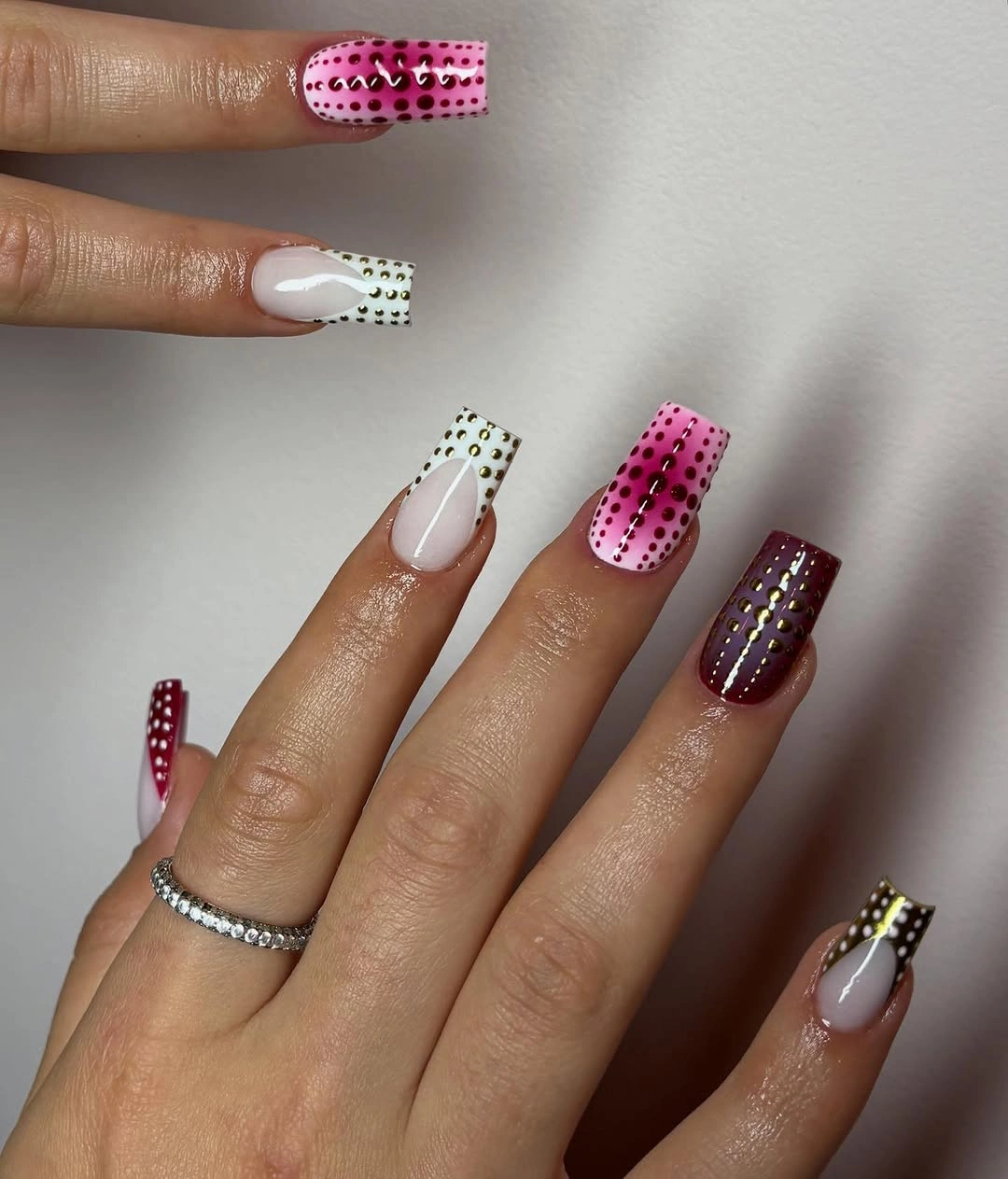 White burgundy square nails with graphic dots and metallic borders