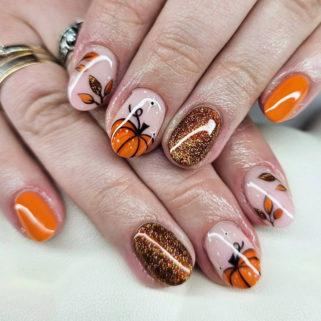 Orange blush nails with brown glitter and seasonal accents
