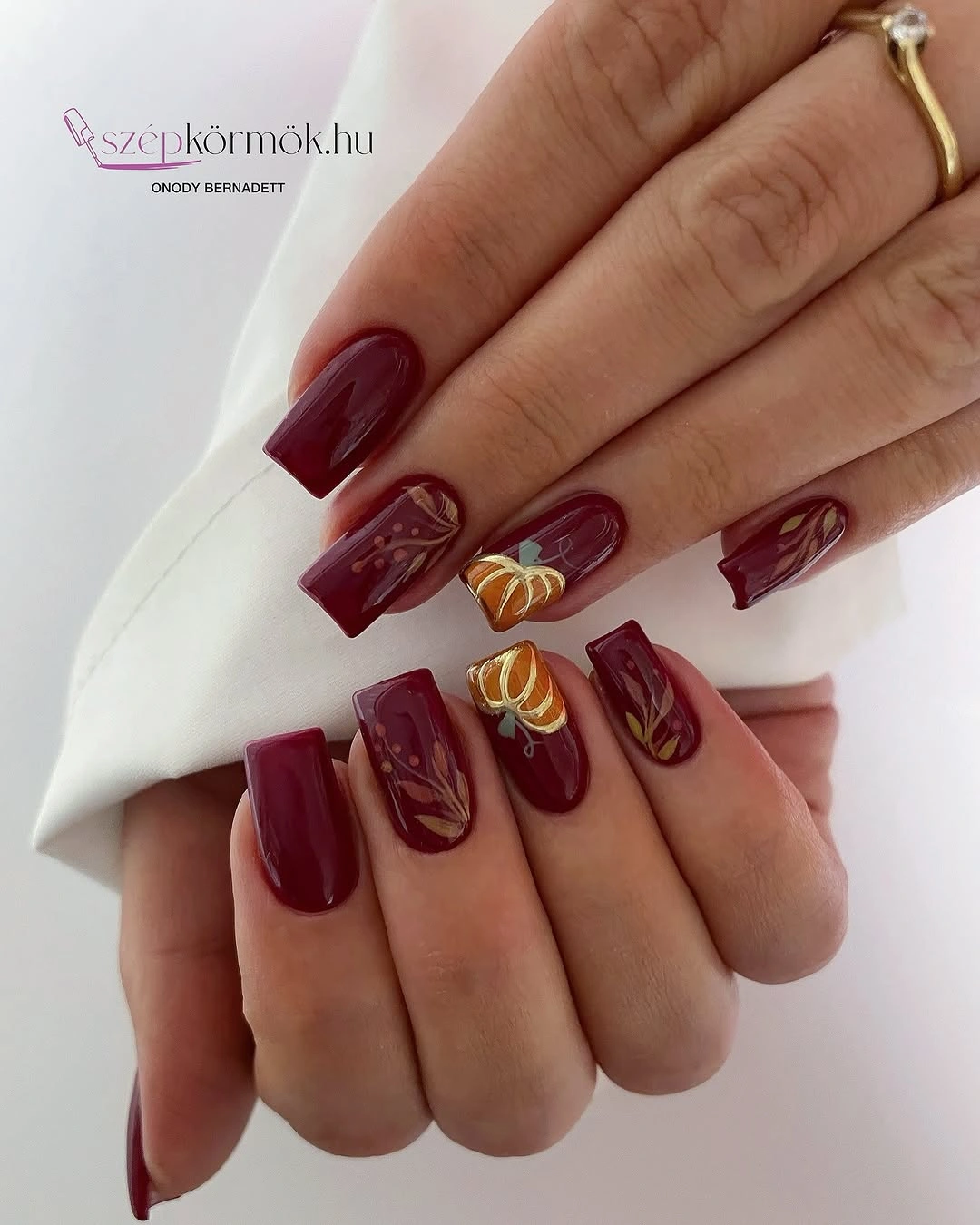 Deep burgundy square nails with fine gold line details