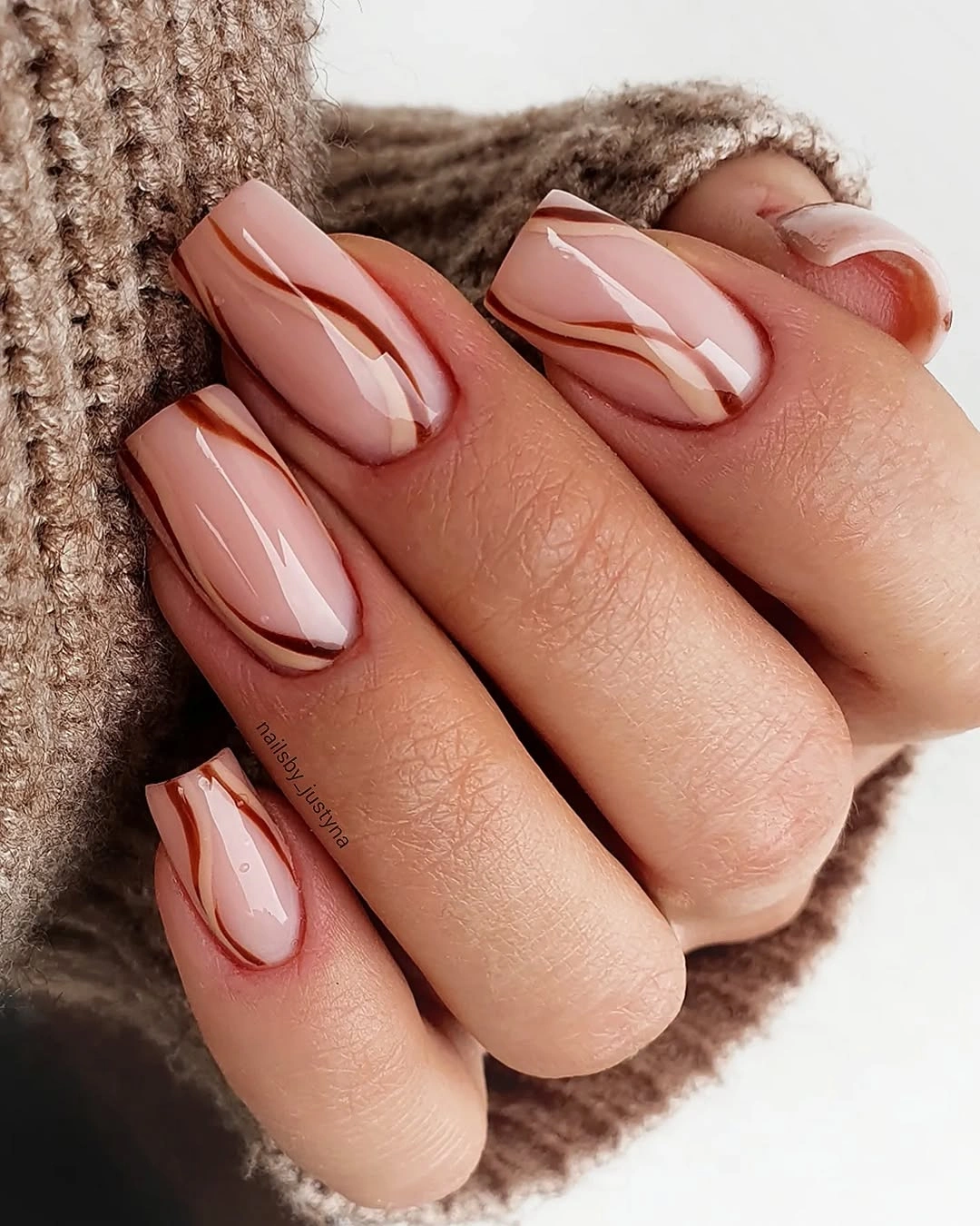 Sheer blush almond nails with brown white swooshes