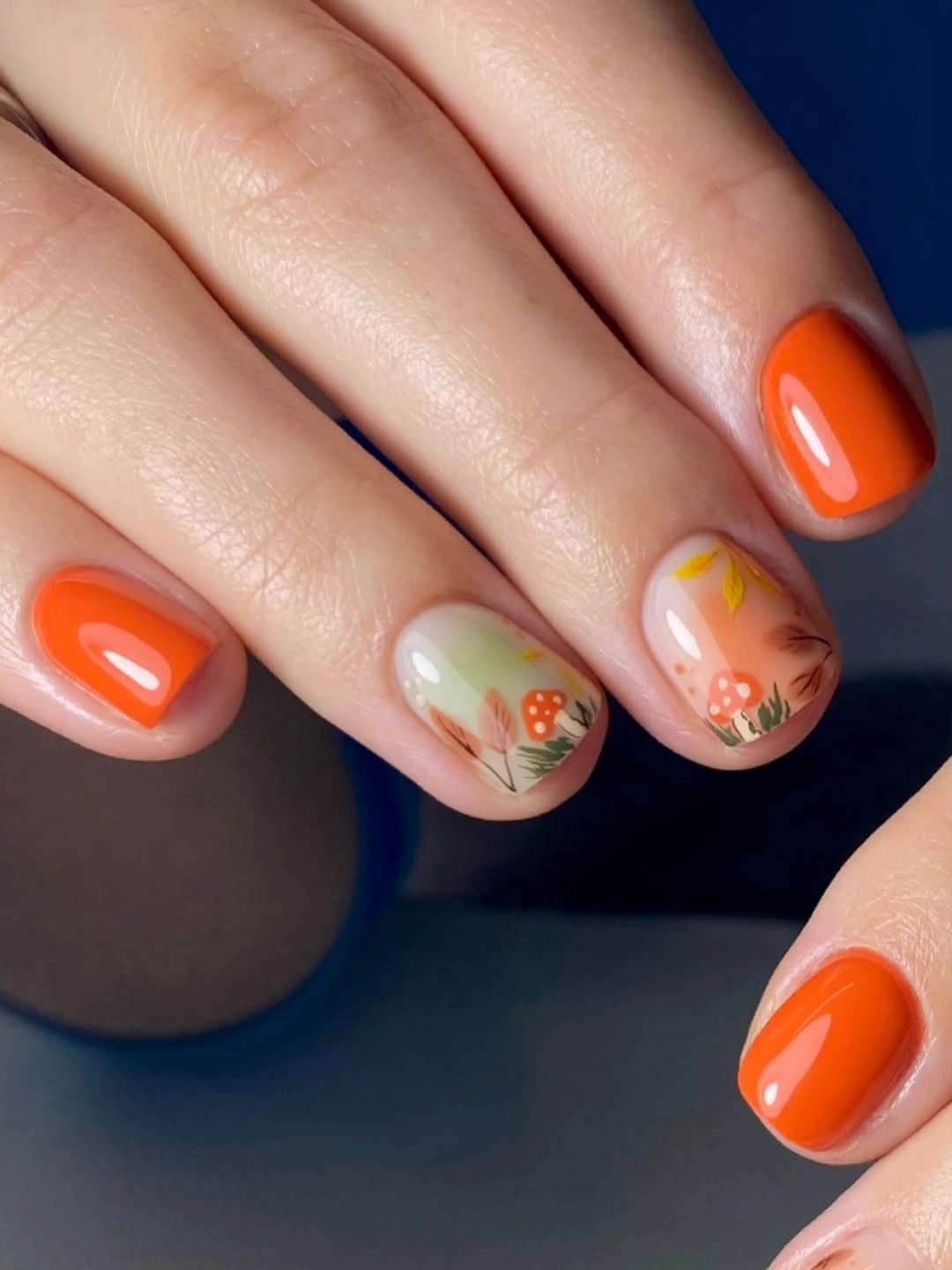 Bright orange square nails with tiny green seasonal marks