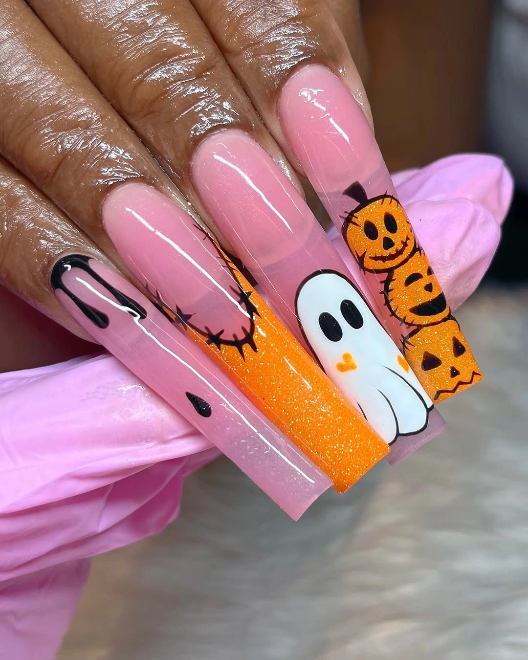 Long almond nails with nude bases brown curved panels and floral details