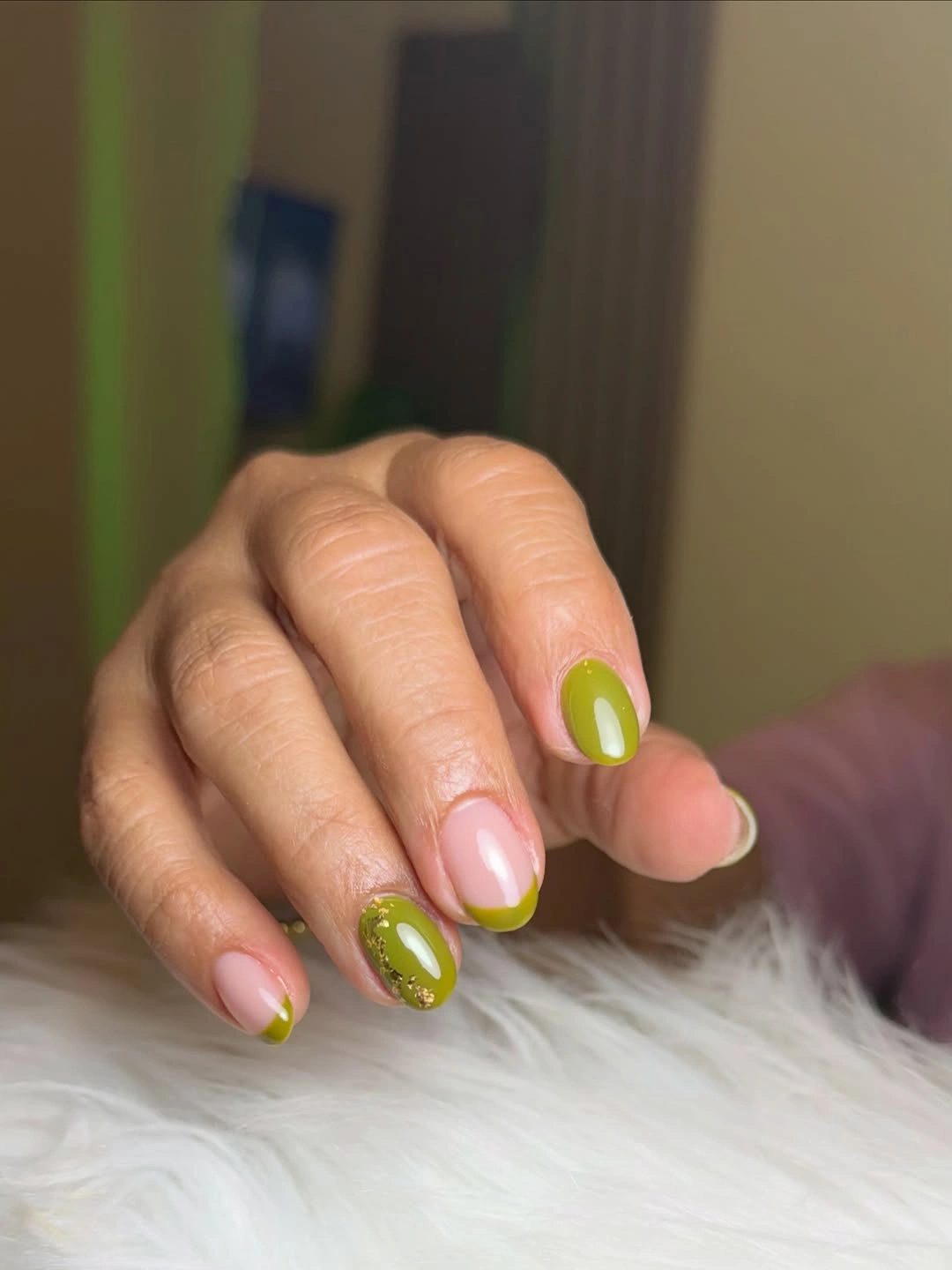 Short olive nails with nude tips and gold flecks