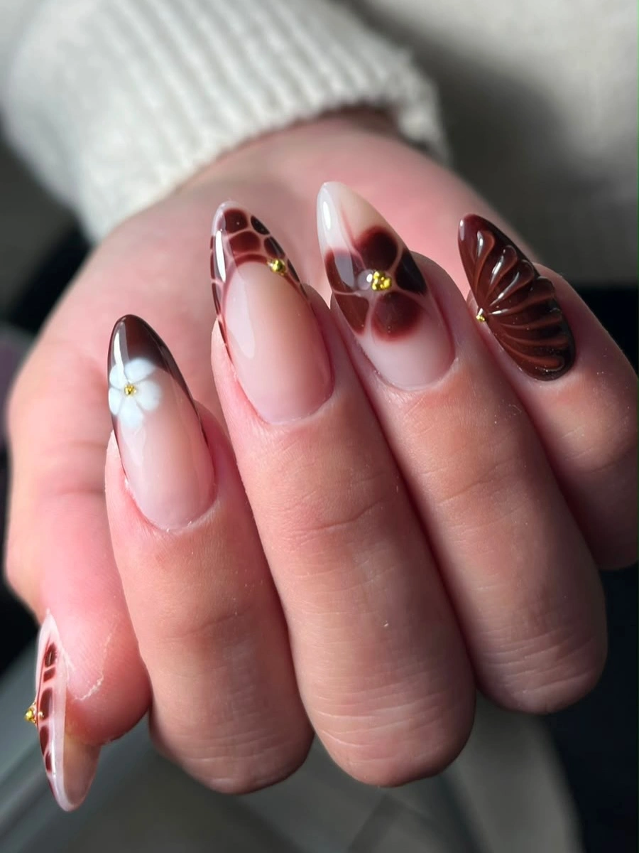 Burgundy petal tip accents on nude almond nails