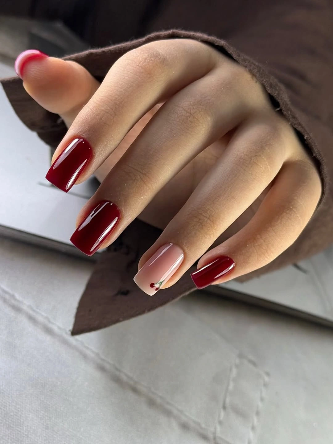 Burgundy square nails with a tiny cherry accent