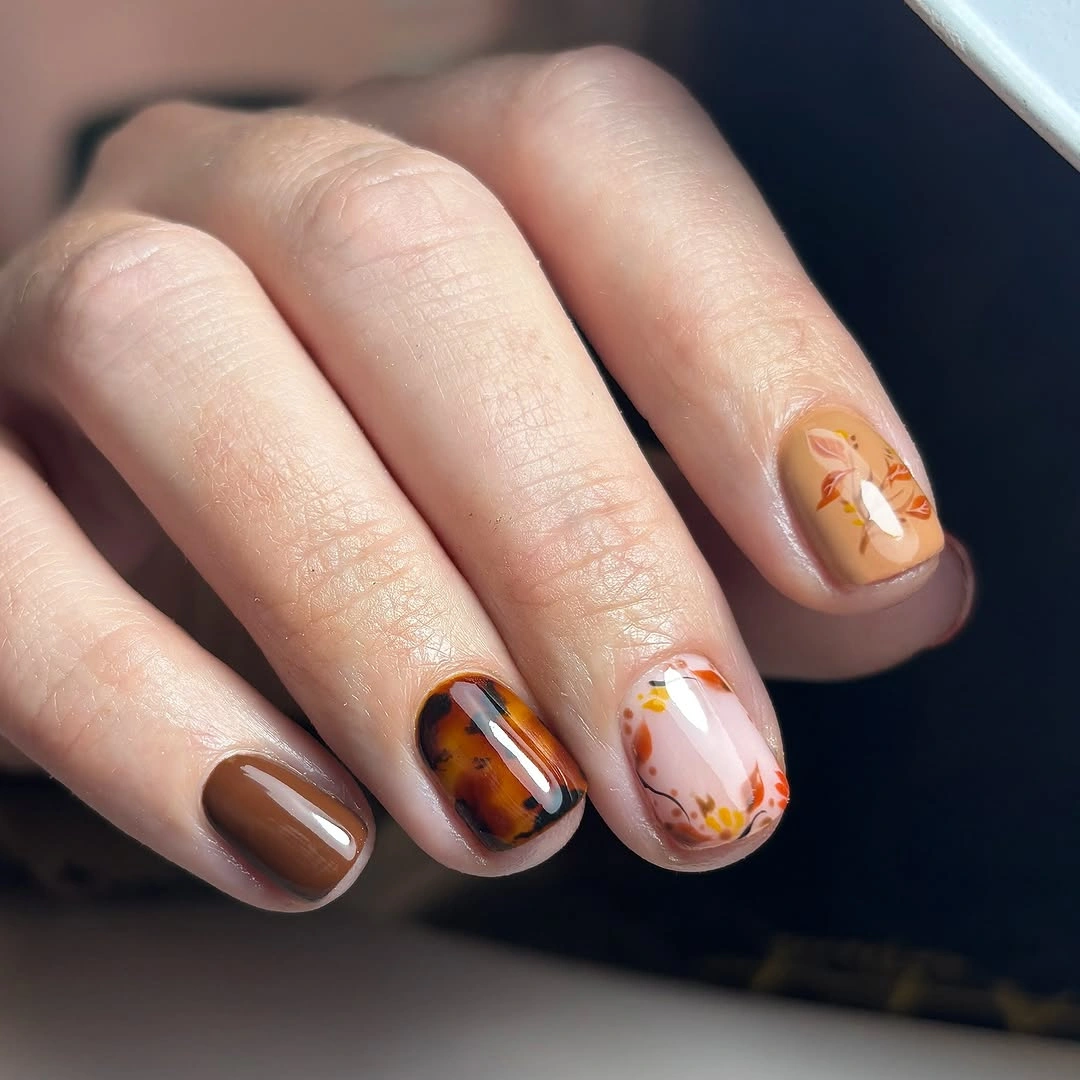 Short brown nails with tortoiseshell and leaf accents