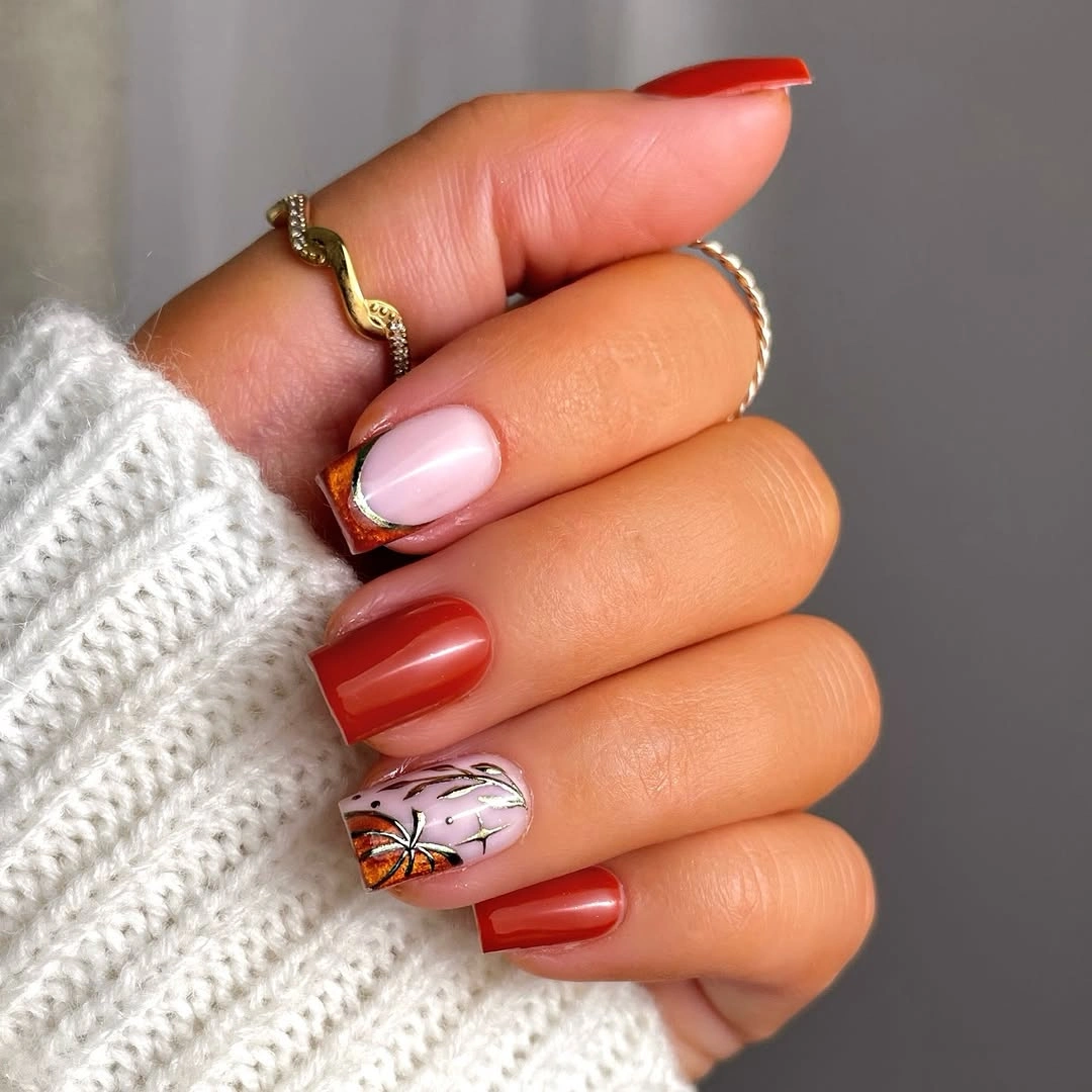 Red orange square nails with a pale leaf accent