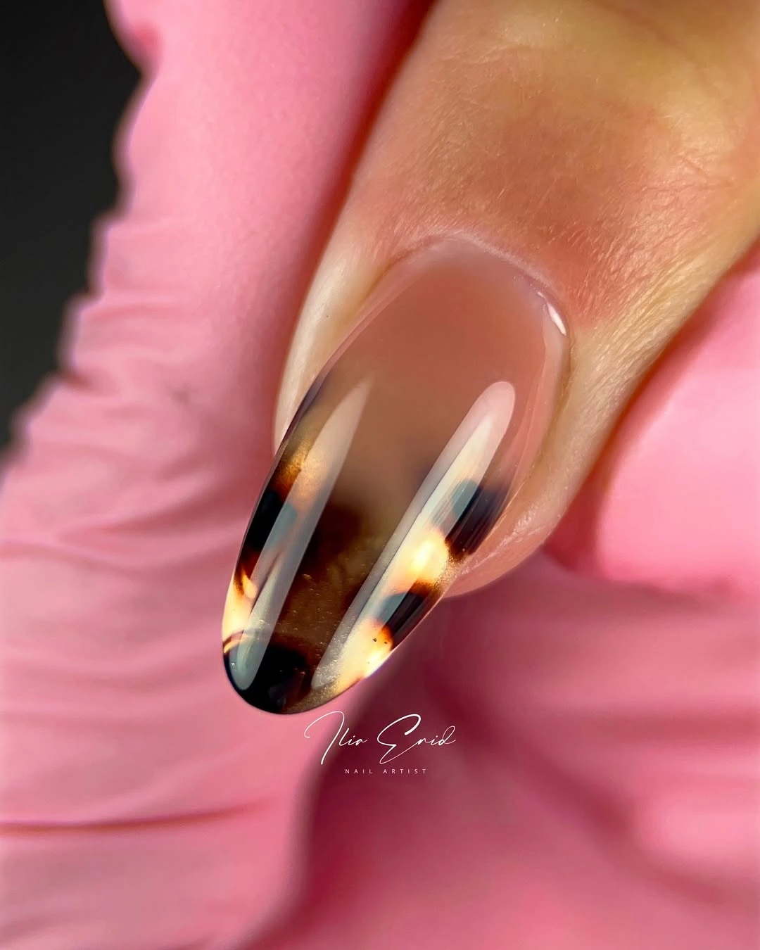 Sheer pink stiletto nails with amber and black accents