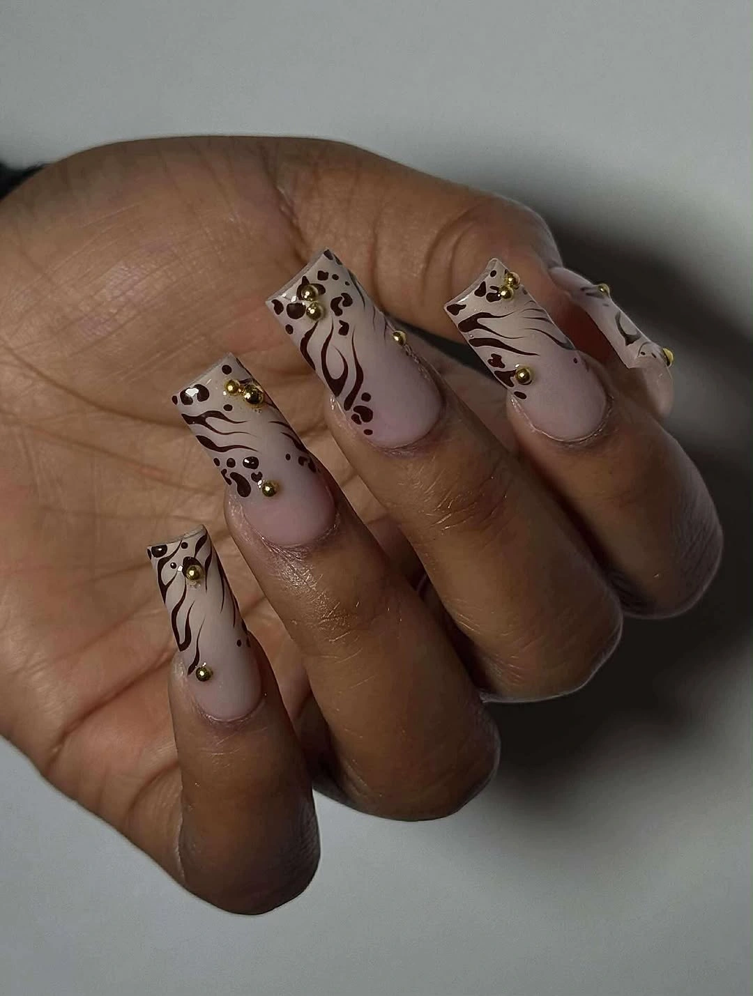 Long neutral almond nails with dark brown animal-like line motifs