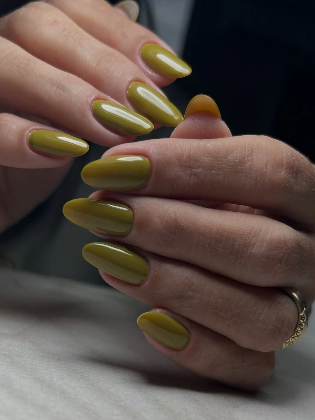 Medium-long almond nails in a single glossy olive green shade