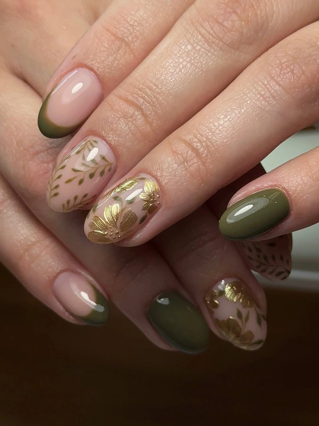 Medium almond nails in muted olive green and sheer nude with gold details