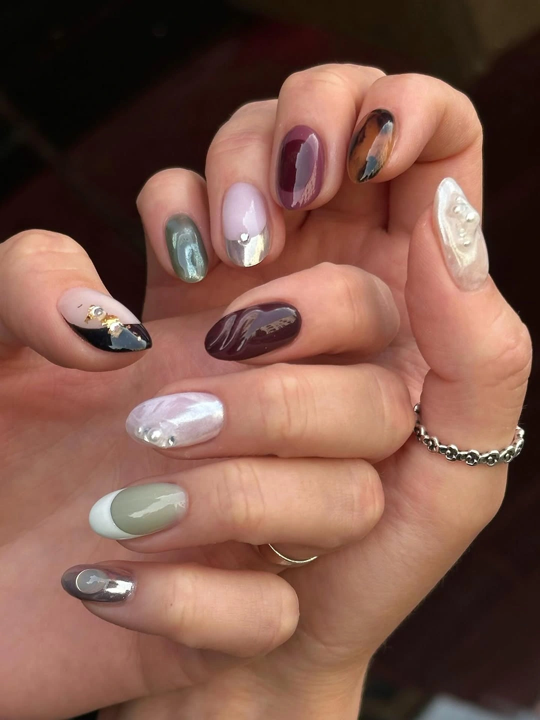 Long almond nails in mauve, pale blue, cream, and plum