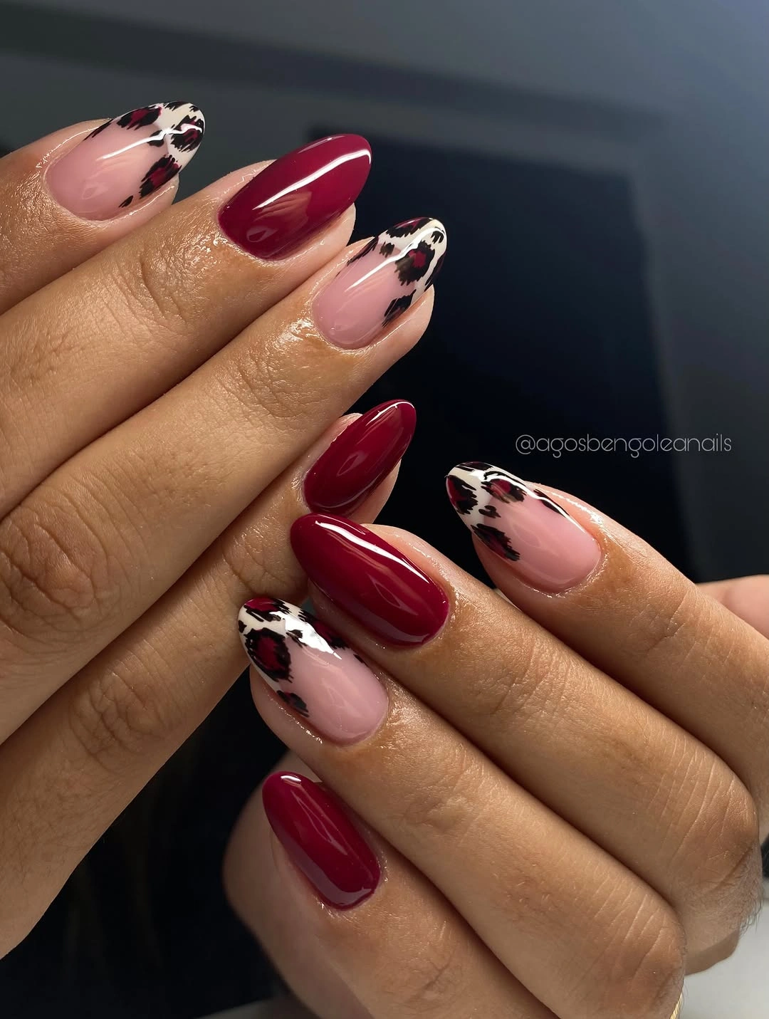 Long almond nails in sheer pink, deep wine, and spotted accents