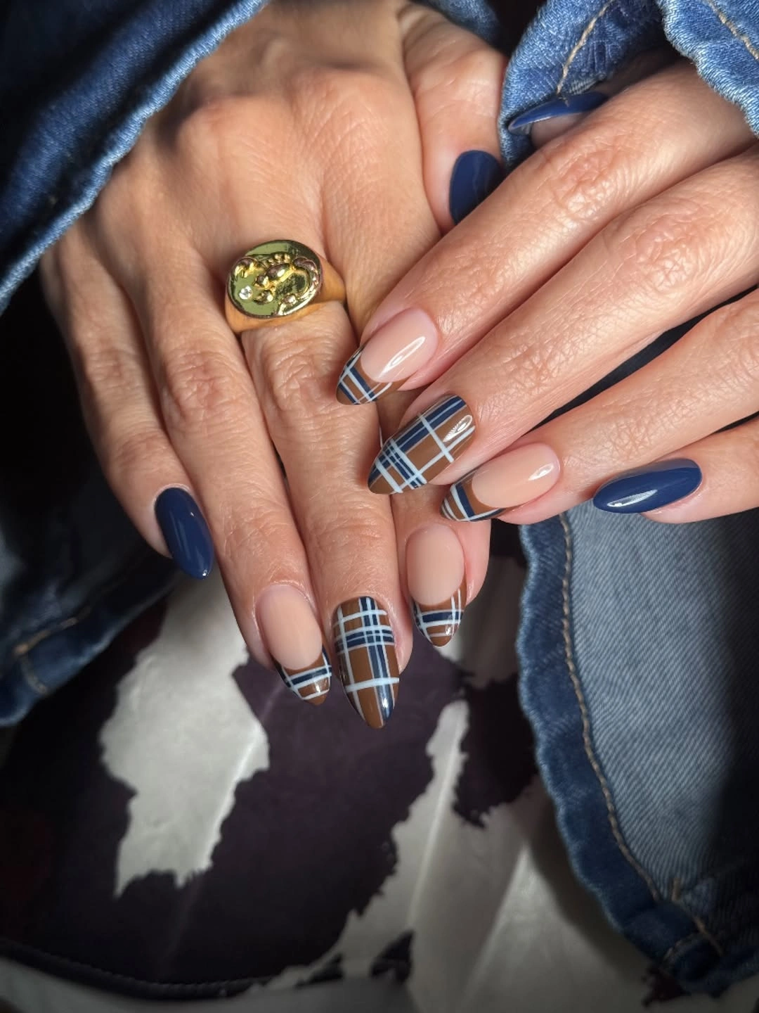 Medium almond nude nails with navy lines and plaid-like accents