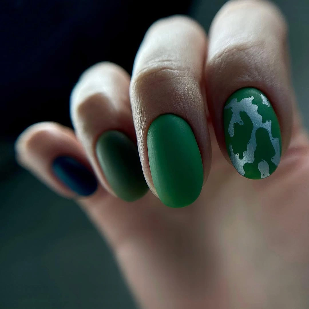 Short dark green oval nails with pale organic pattern accents