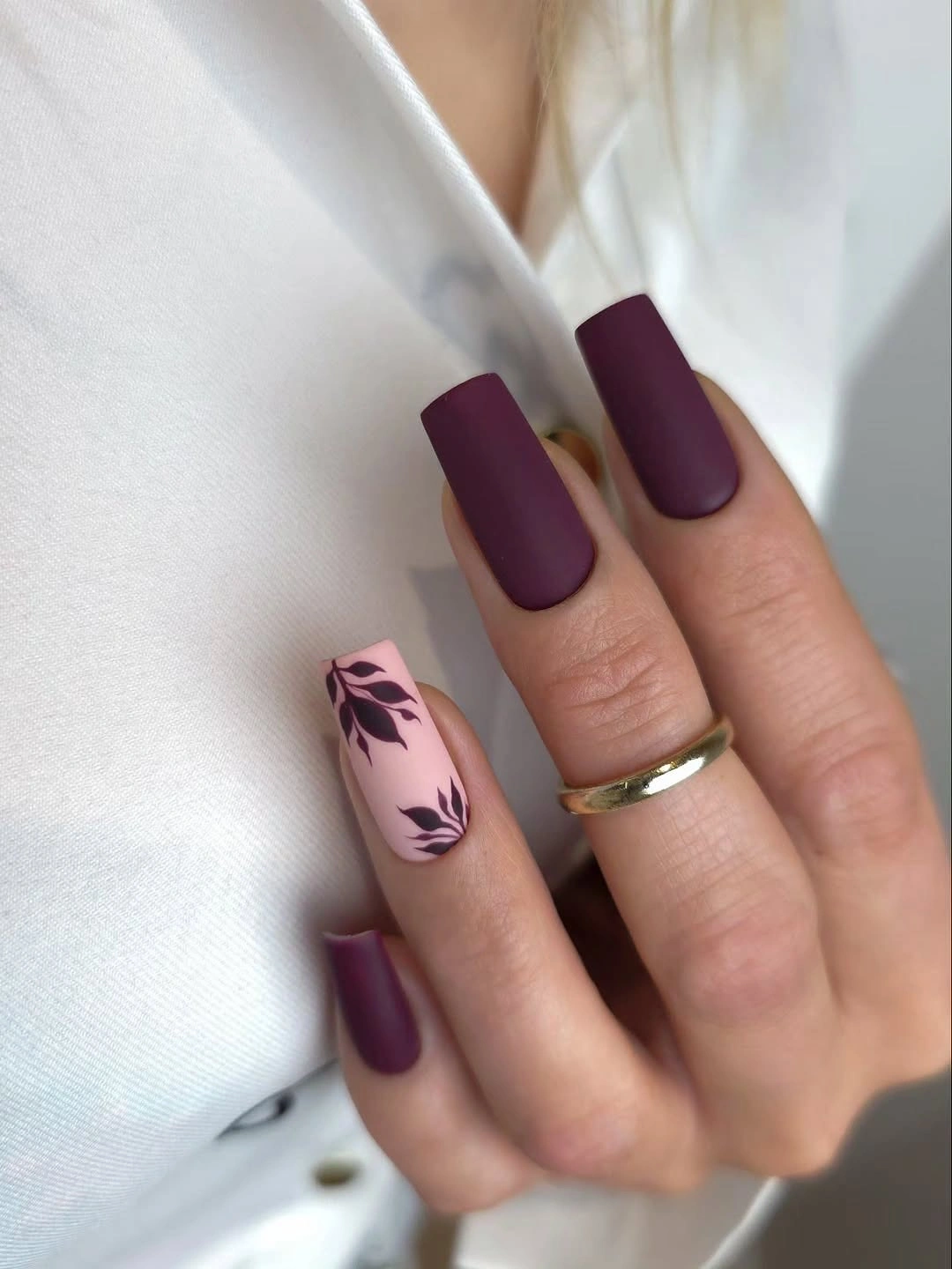 Long plum matte square nails with one pale leafy accent nail