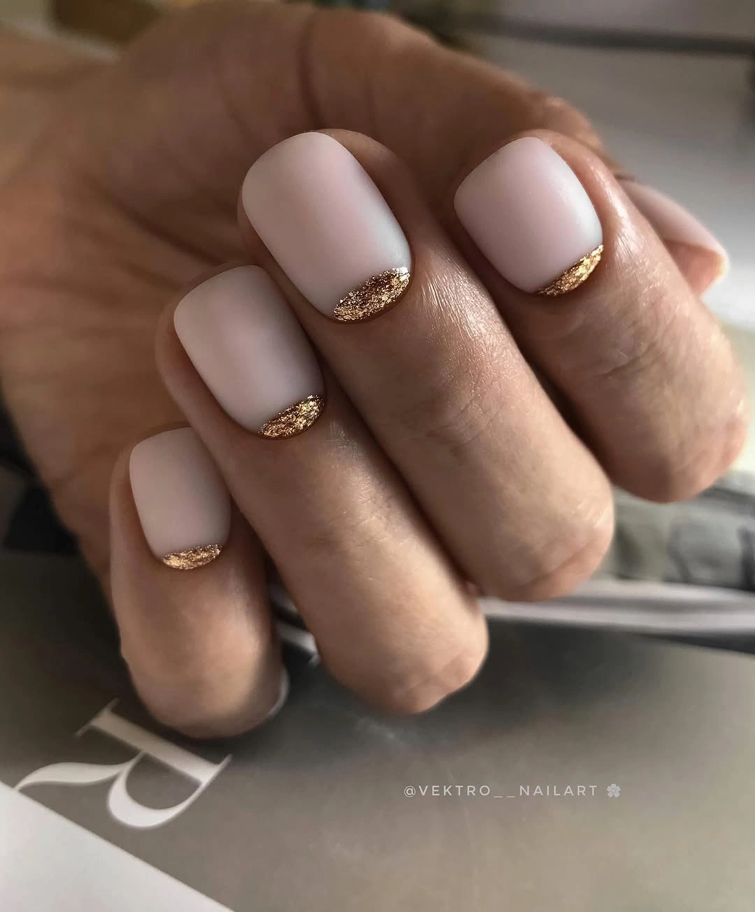 Short pink rounded square nails with narrow gold glitter tips