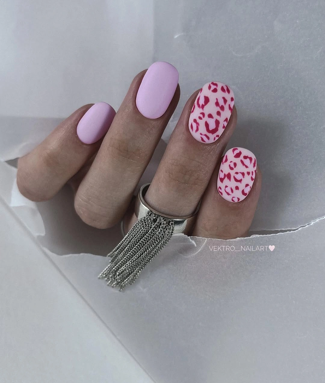 Short lavender oval nails with two red animal print accents