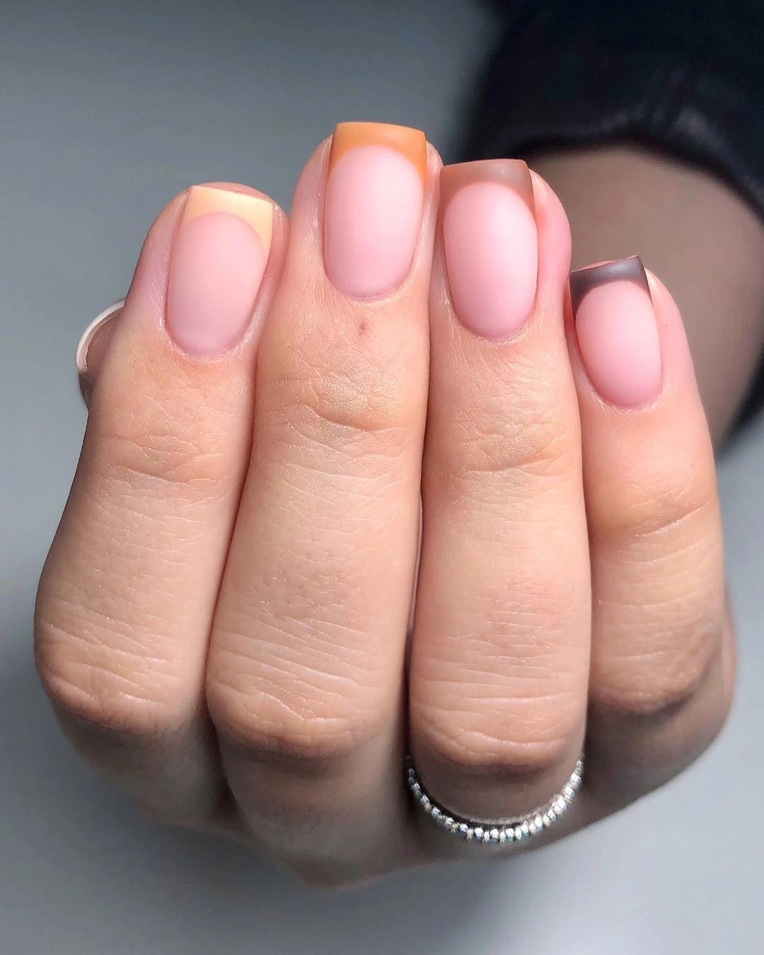 Short soft pink nails with delicate pale tips and rounded edges