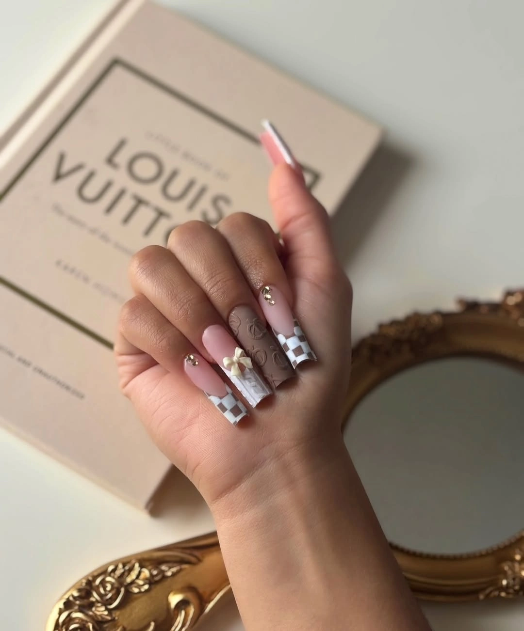 Pink square nails with dark line art and chrome accents