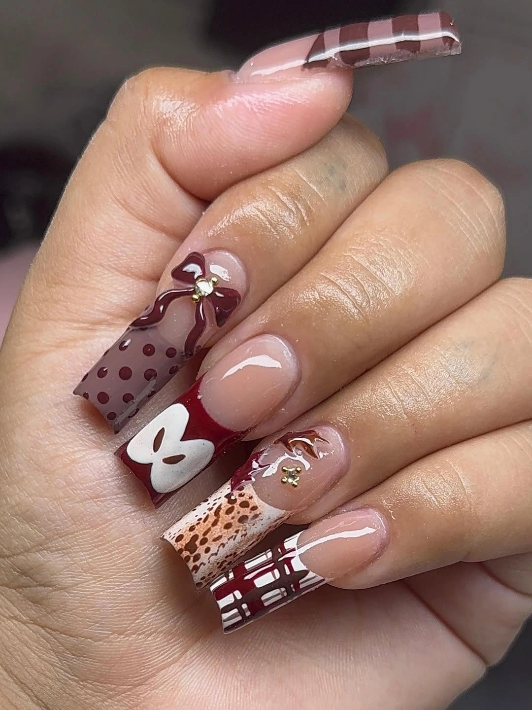 Burgundy patchwork nails with plaid dots and mixed accents