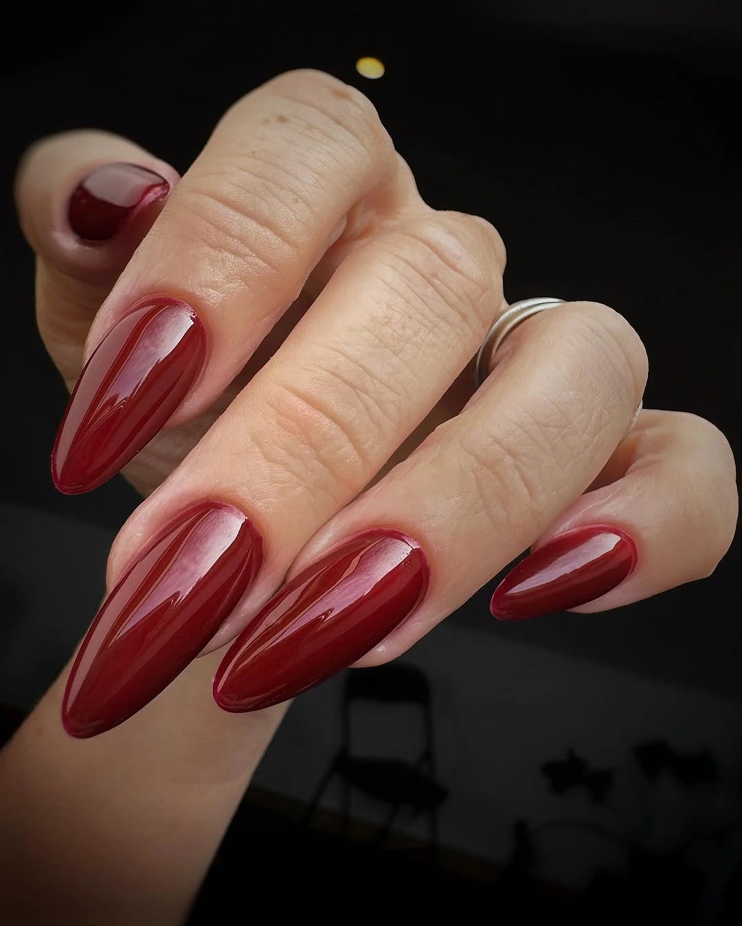 Deep glossy red pointed almond nails