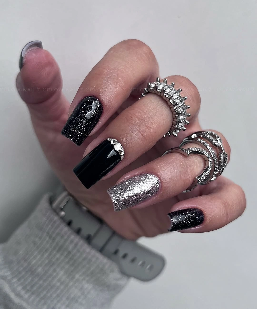 Black and silver glitter square nails with rhinestone accents