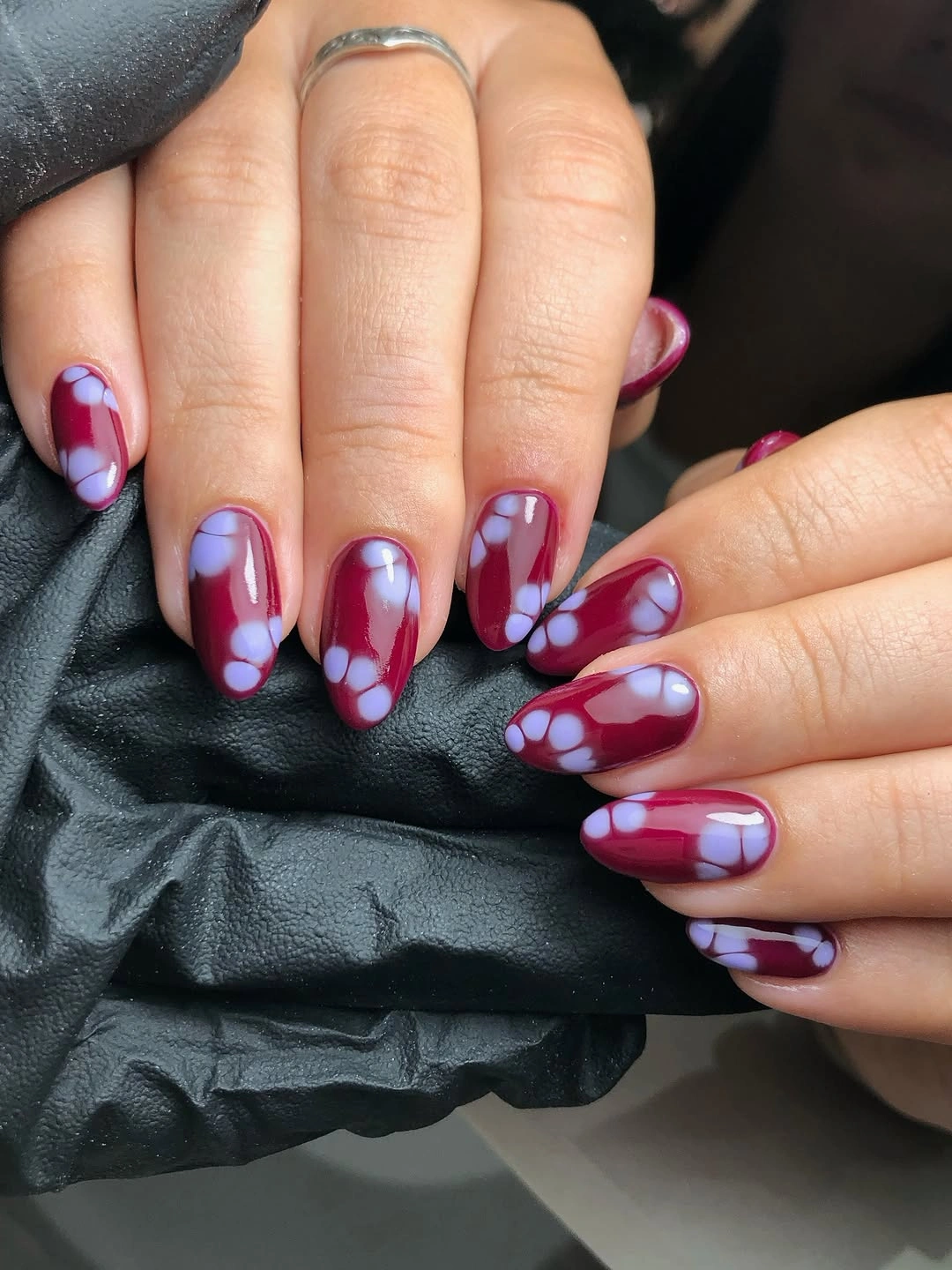 Medium oval nails with berry plum blue and pink curved details