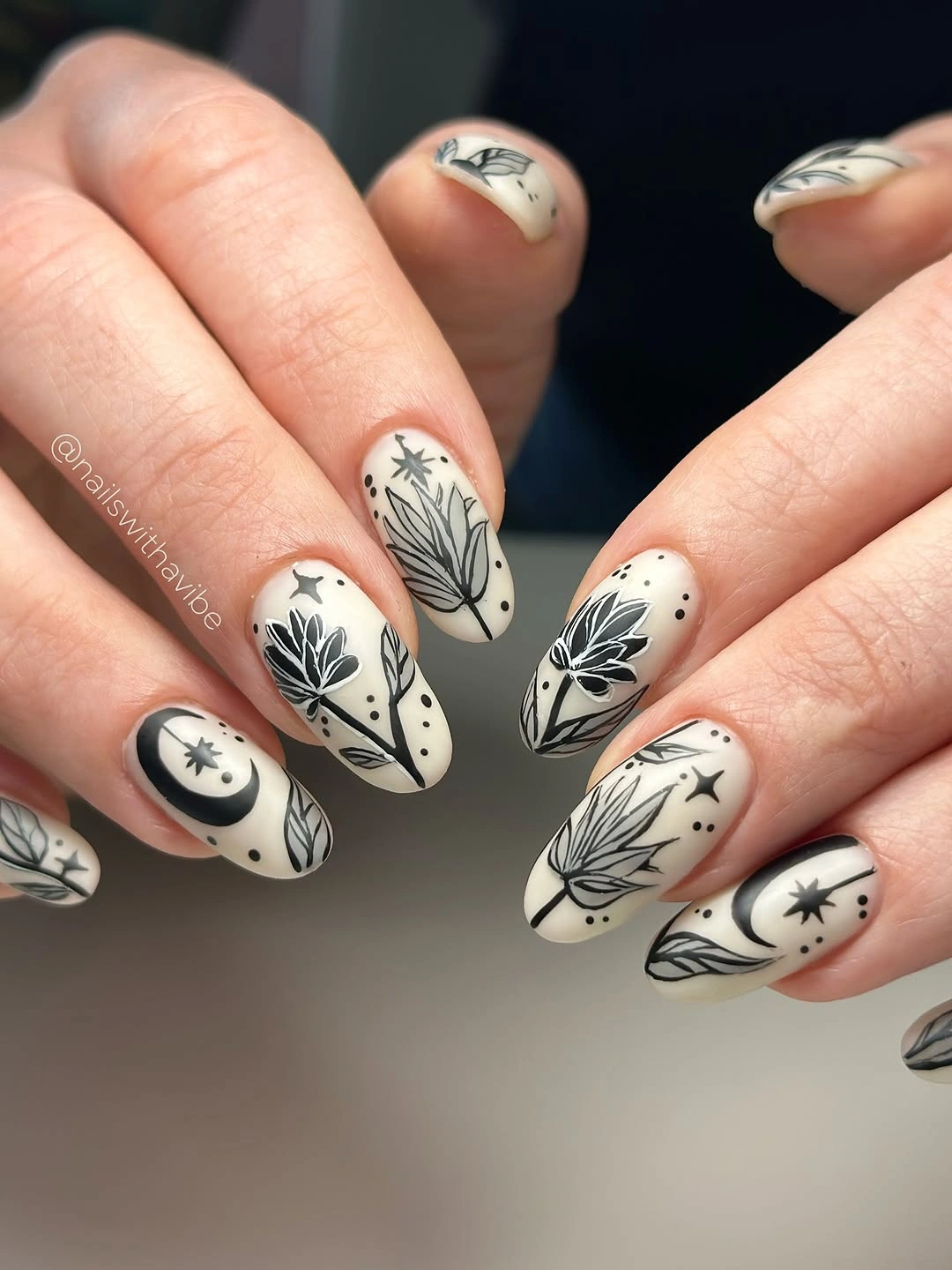 Medium almond ivory nails with black botanical line art