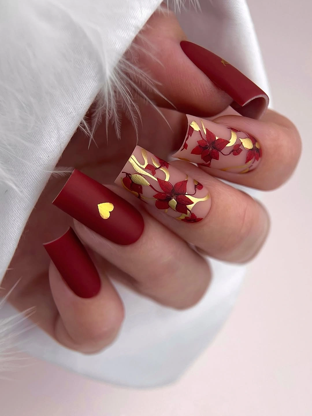 Medium tapered red nails with gold botanical accents