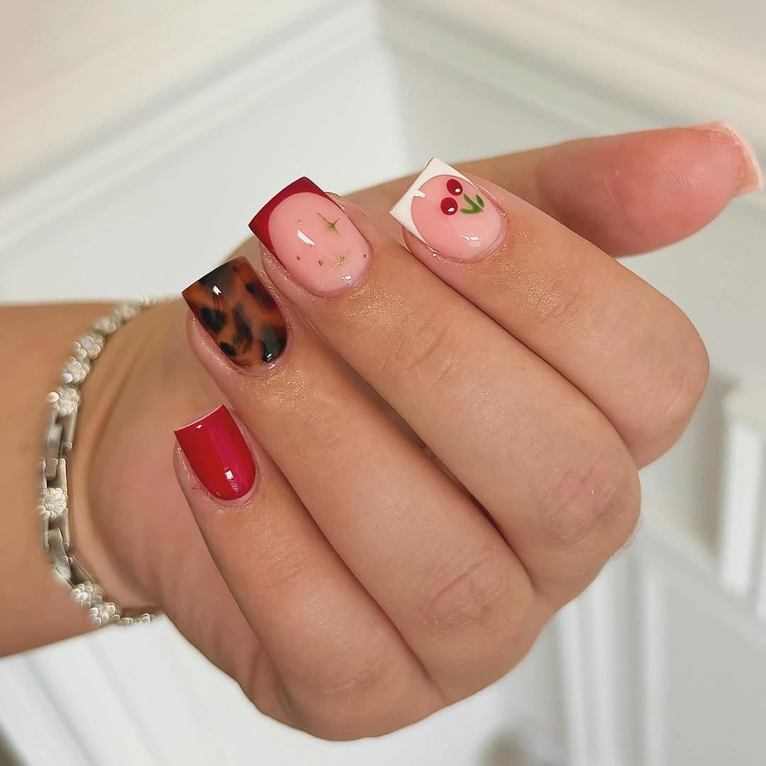 Short red tortoise nails with cherry accent