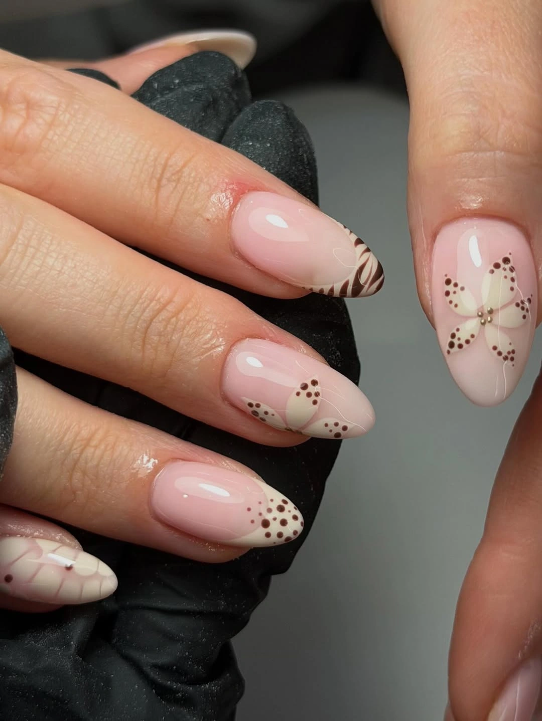 Milky almond nails with brown dotted flowers