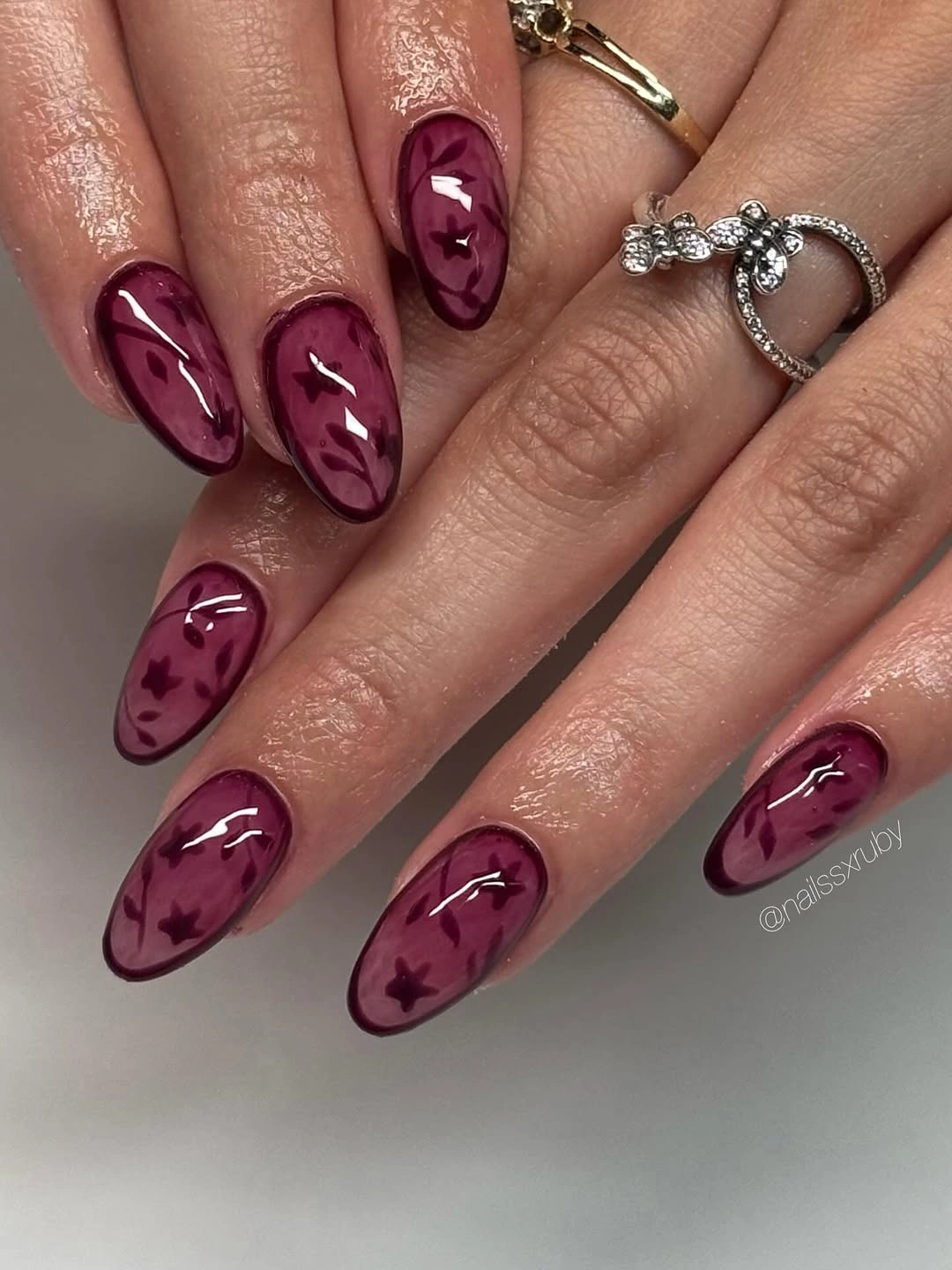Sheer wine almond nails with tonal leaves