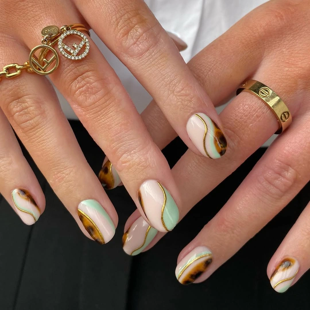 nude almond nails with green orange French lines